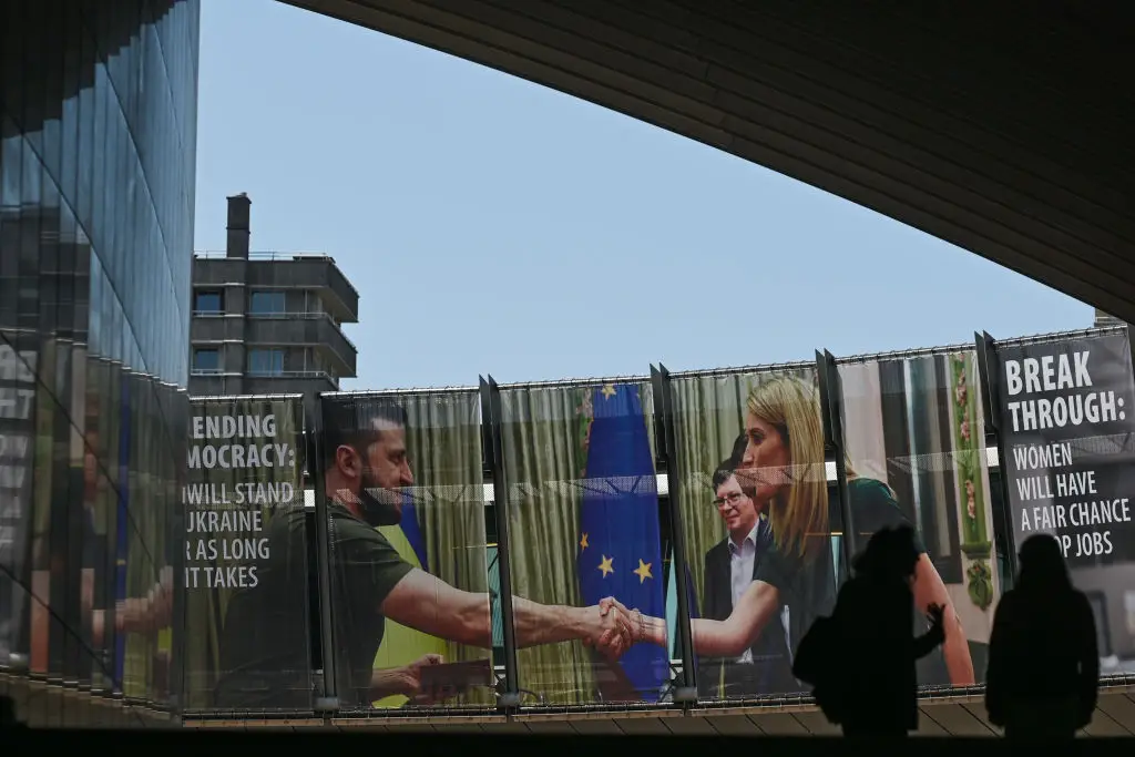 Em Bruxelas, um cartaz mostra um cumprimento entre Volodymyr Zelensky (Presidente da Ucrânia) e Roberta Metsola (Presidente do Parlamento Europeu)