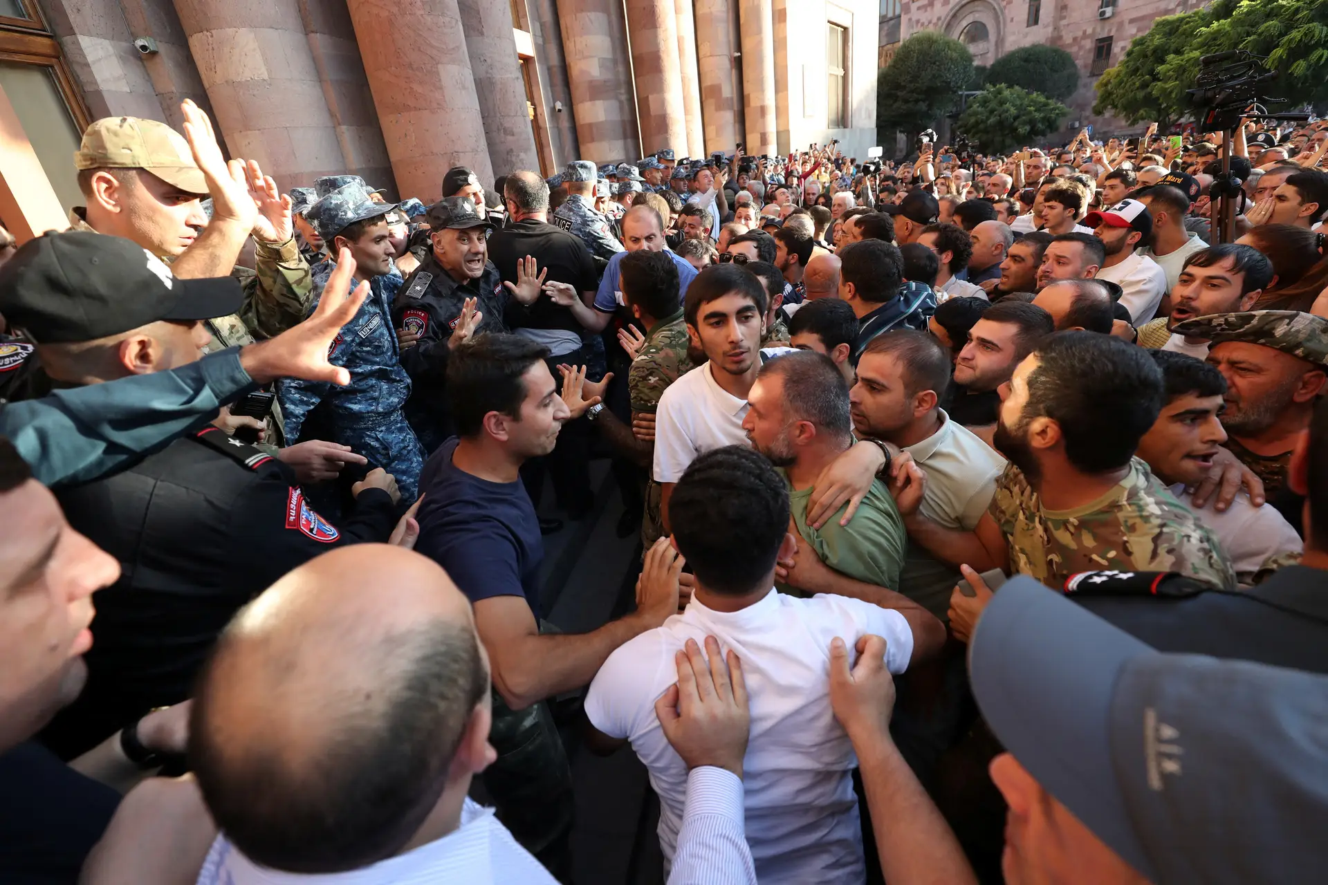 Manifestantes em fúria juntam-se nas proximidades de edifícios governamentais em Yerevan, na Arménia, para protestarem contra nova operação militar em Nagorno-Karabakh 
