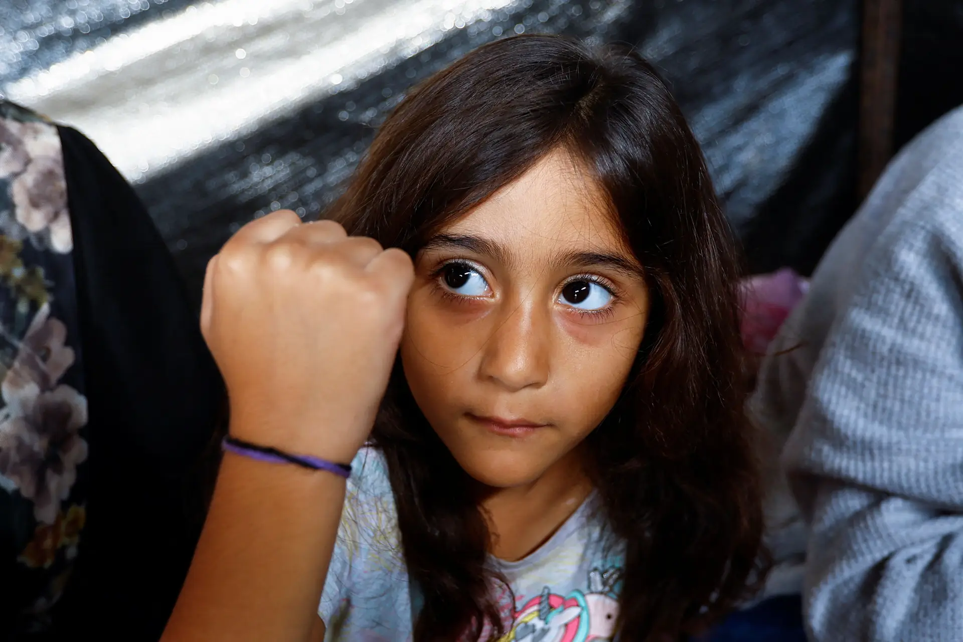 A filha do palestiniano Ali Daba mostra a sua pulseira no seu abrigo em Khan Younis, no sul de Gaza