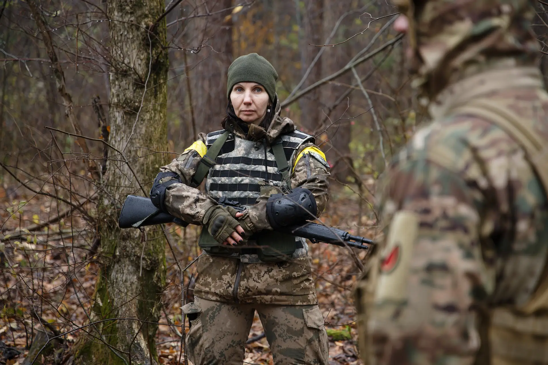 Uma mulher em uniforme militar e com uma espingarda automática nas mãos durante um exercício em 11 de novembro de 2023 em Kiev, na Ucrânia.