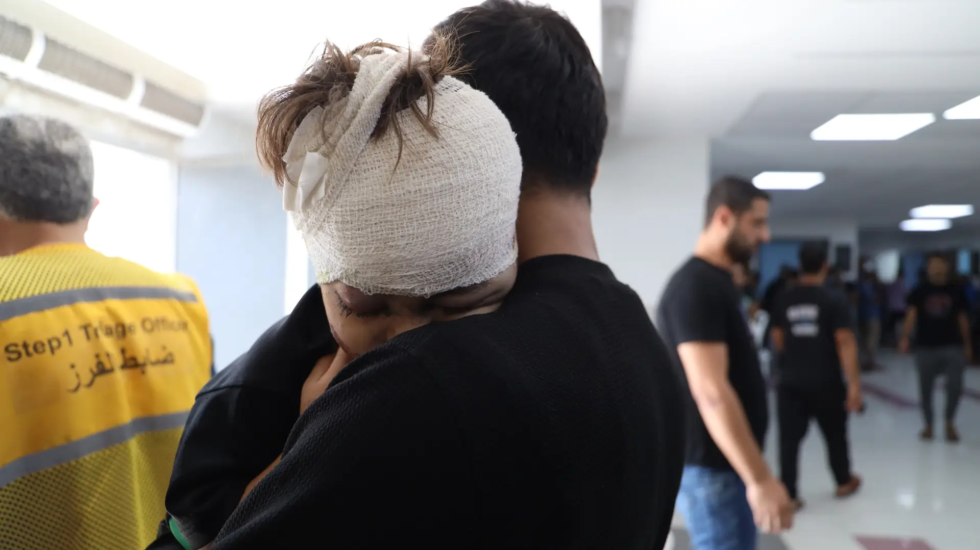 Uma criança com o sei pai depois de receber tratamento no hospital de al-shifa