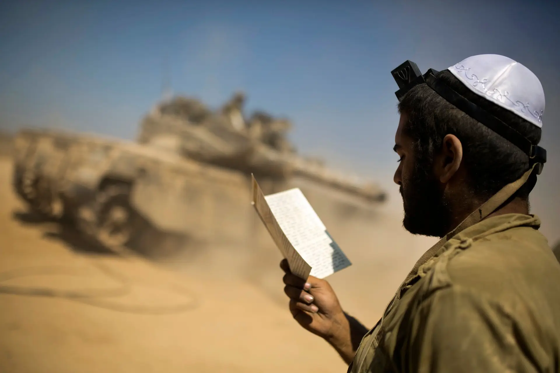Soldado israelita em oração, numa área de movimentações militares, junto à Faixa de Gaza