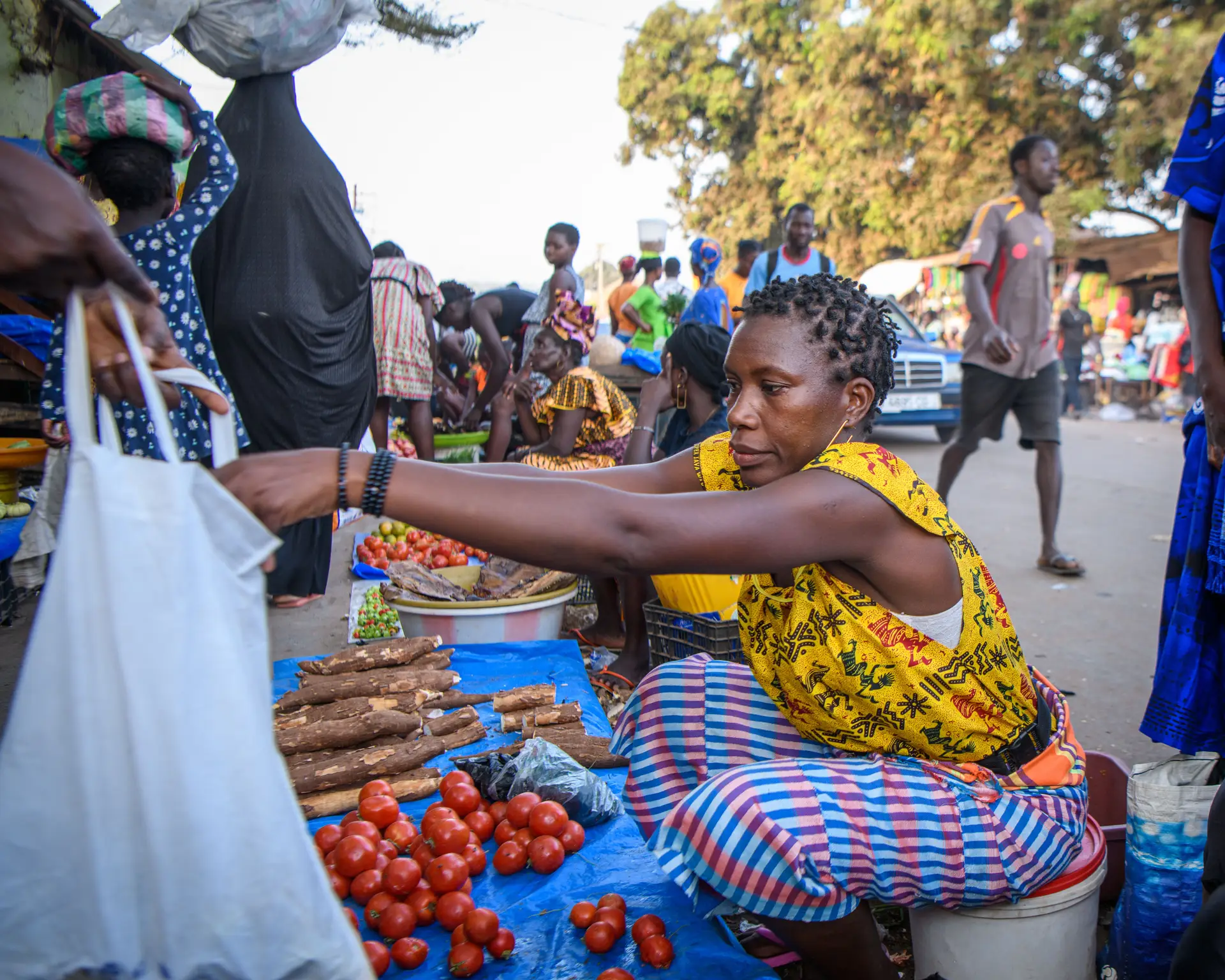 Uma mulher vende frutas e legumes no mercado, em Bissau.