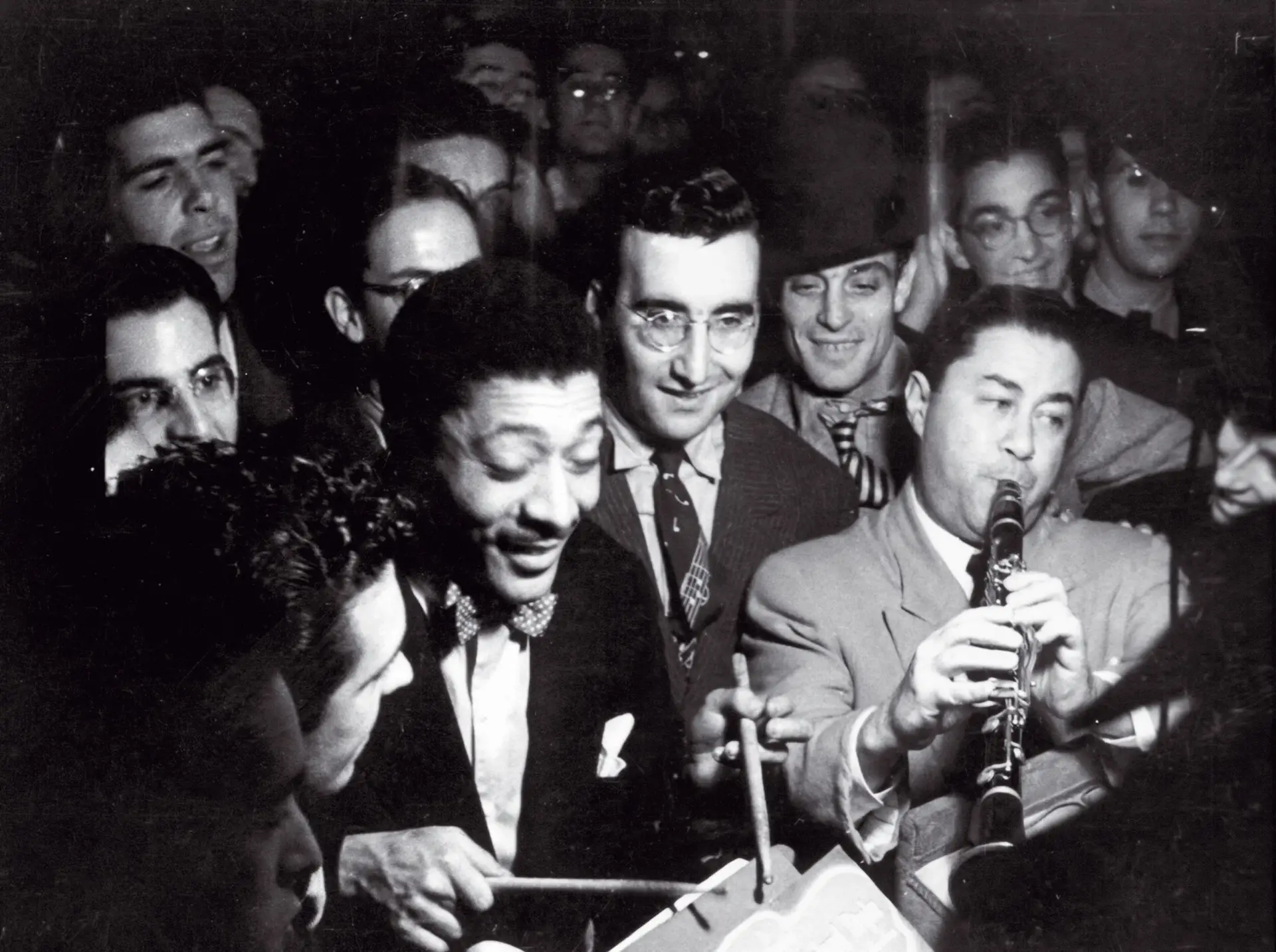 Luís Villas-Boas (ao centro, de óculos) entre Pops Whitman (percussão, à esq.) e Art Carneiro (clarinete, à dir.) na “primeira jam session”, no Café Chave de Ouro, em 1948. “Rapazes e raparigas lisboetas [...] dominados pelos ritmos e variações selvagens e imprevisíveis”, escrevia “O Século”