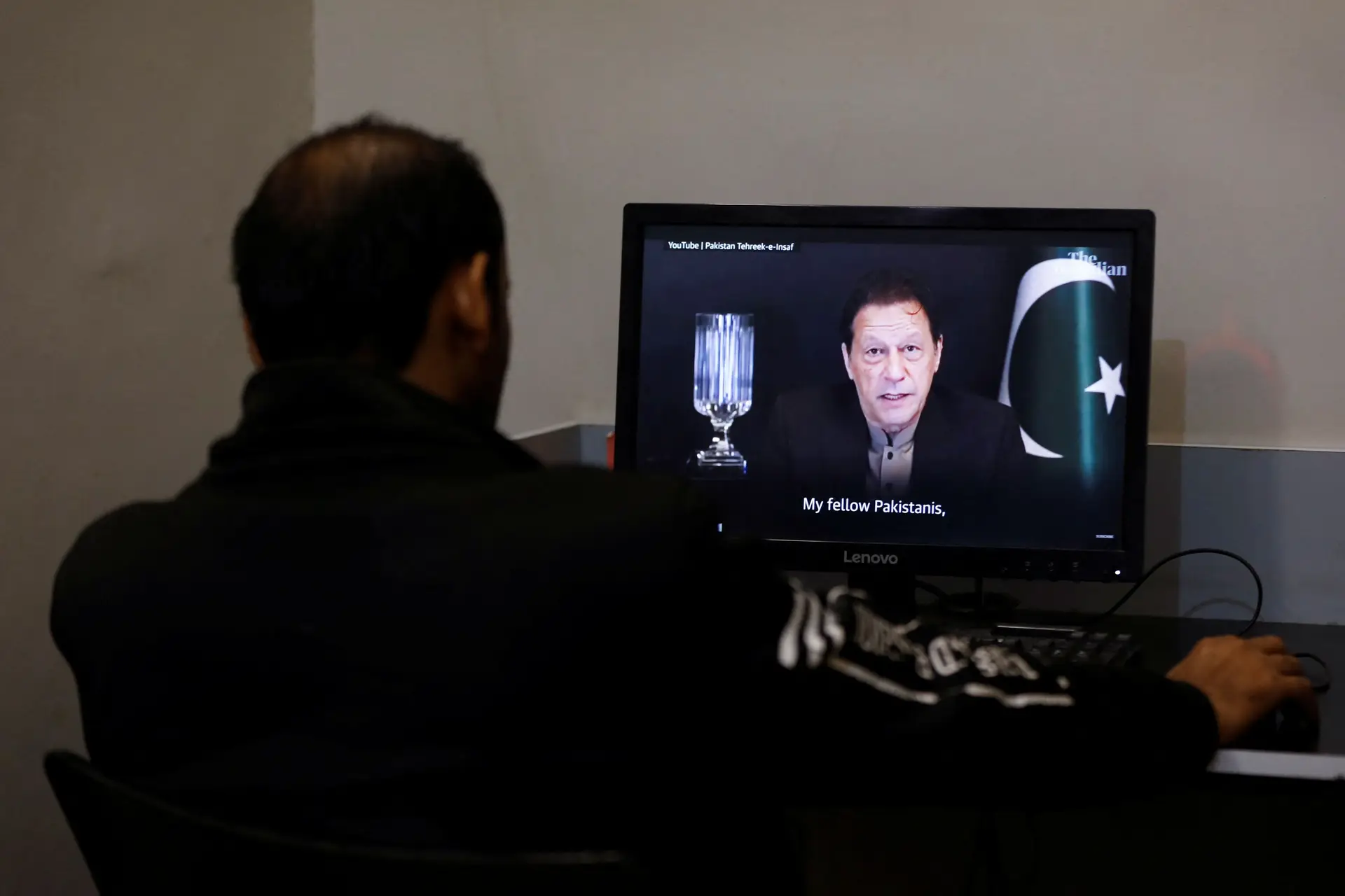 Em Karachi, um paquistanês assiste a uma mensagem de Imran Khan em que, quer a imagem, quer a voz foram geradas por inteligência artificial