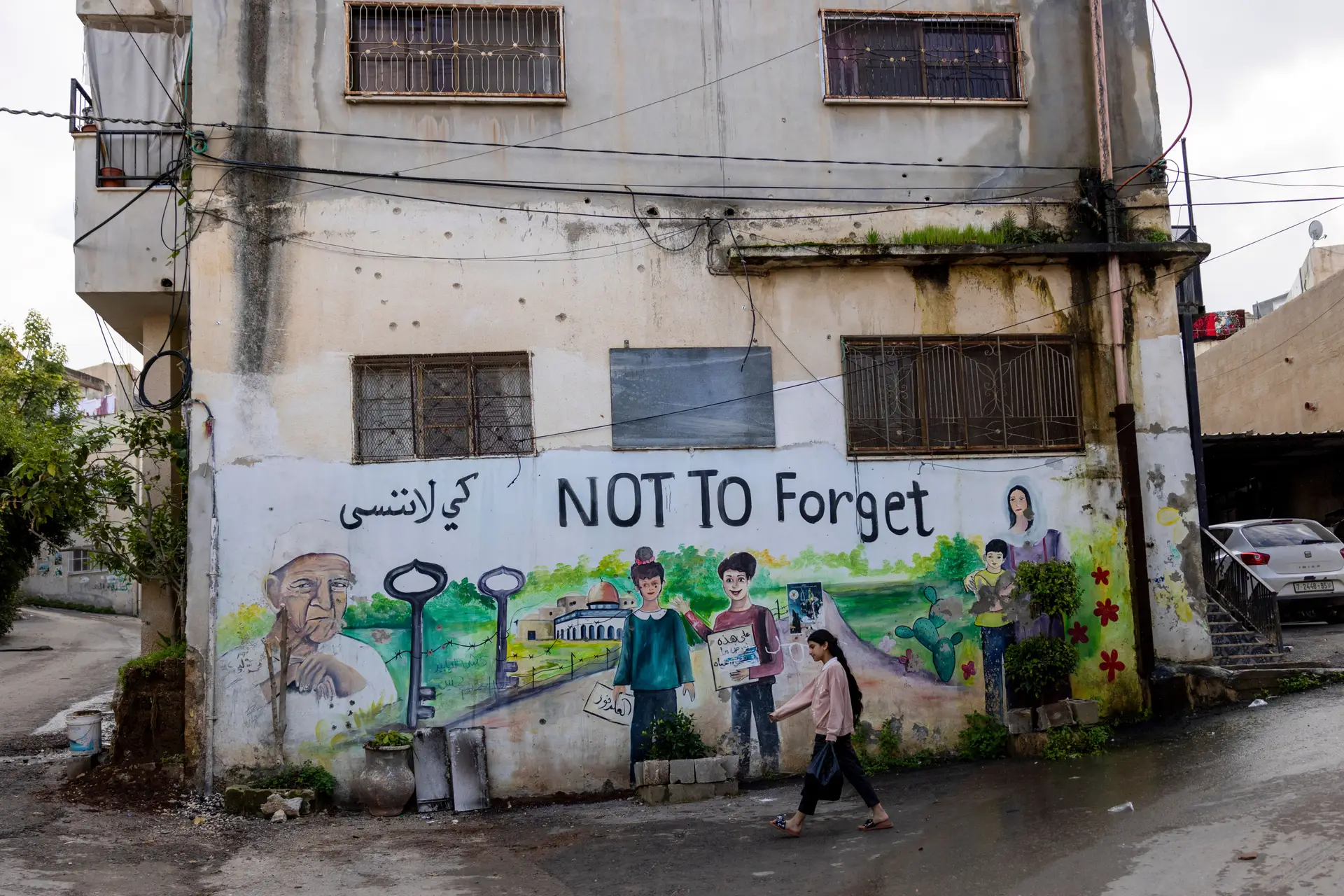 Na Cisjordânia, uma criança passa por um grafite que relembra a 'Nakba', ou "Catástrofe", quando centenas de milhares de palestinianos foram expulsos das suas casas em 1948