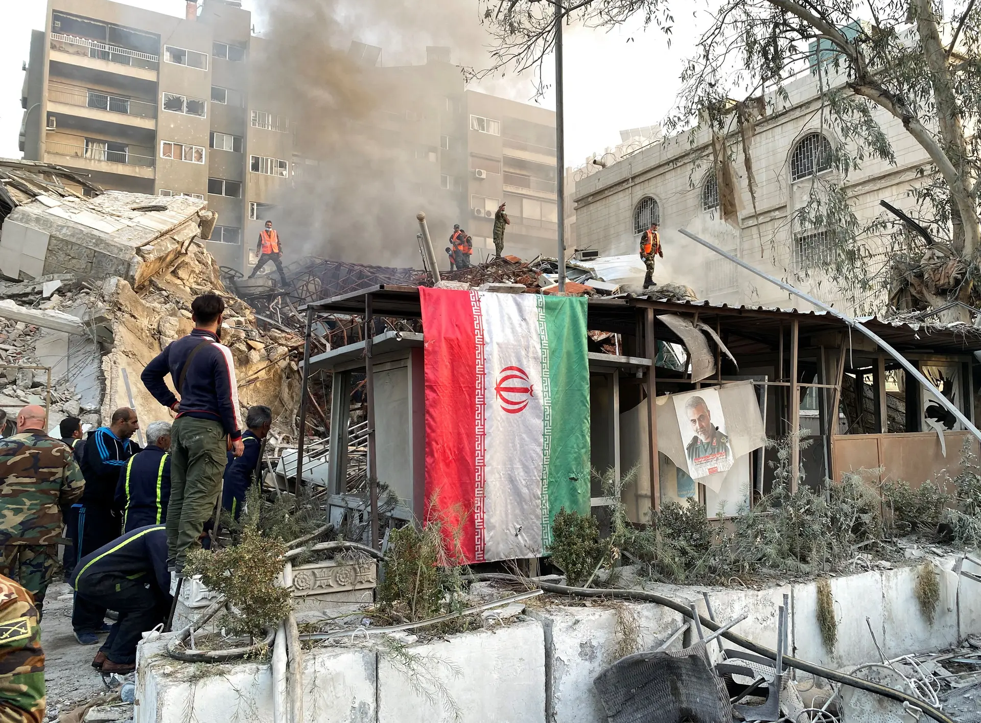 Bandeira do Irão junto aos escombros em que se transformou o consulado iraniano em Damasco, atingido por mísseis