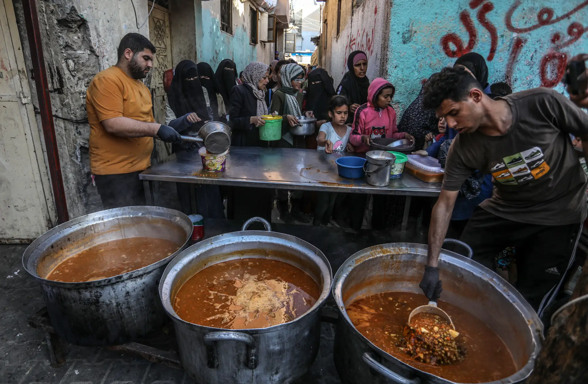 Palestinianos fazem fila para receber ajuda alimentar em Rafah, no sul da Faixa de Gaza