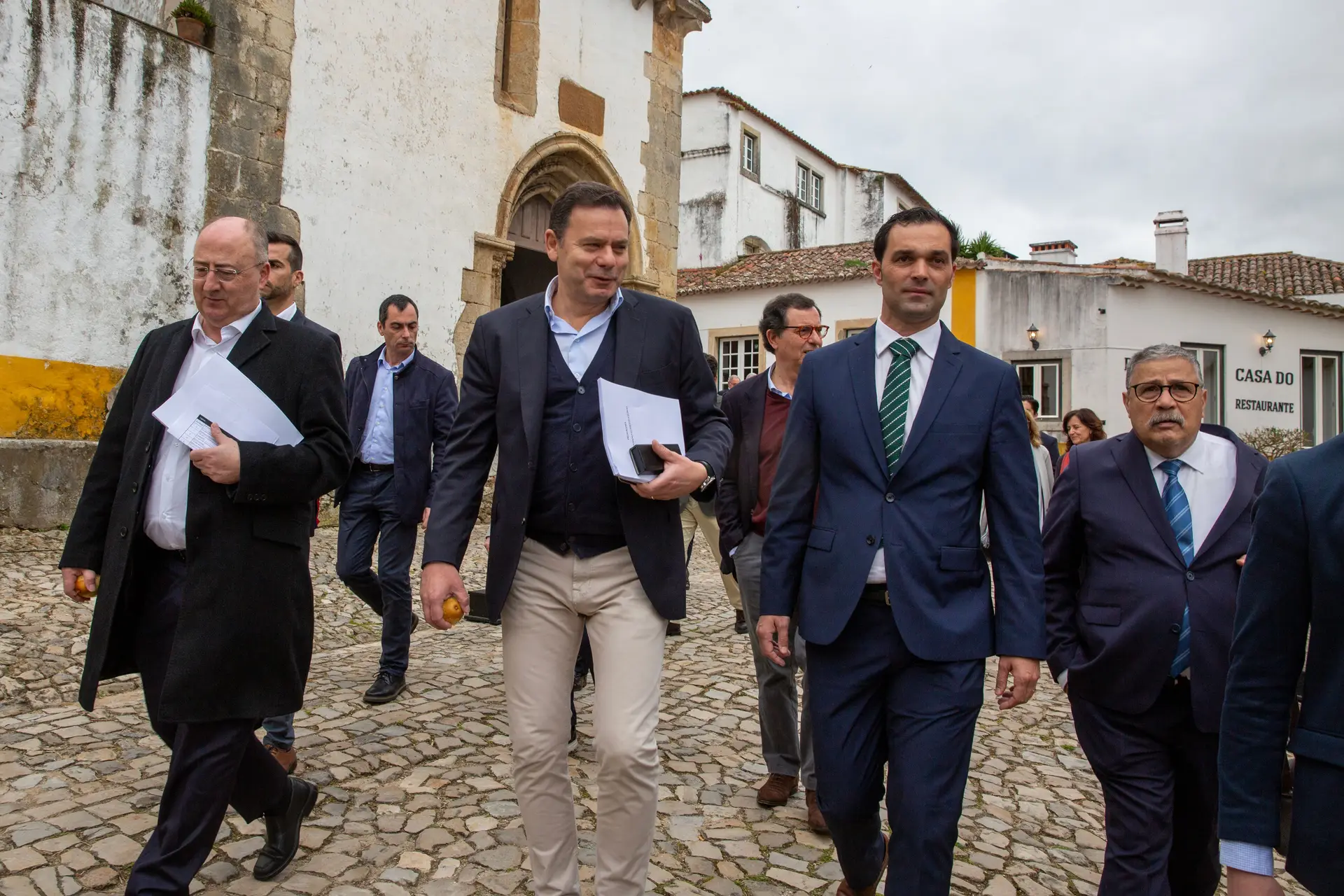 O Primeiro-Ministro Luís Montenegro e o ministro da agricultura, José Manuel Fernandes, seguidos pelos seguintes ministros e secretários de estado atravessam Óbidos em direção a Câmara Municipal, onde vai decorrer o Conselho de Ministros informal. Foto Ana Baião