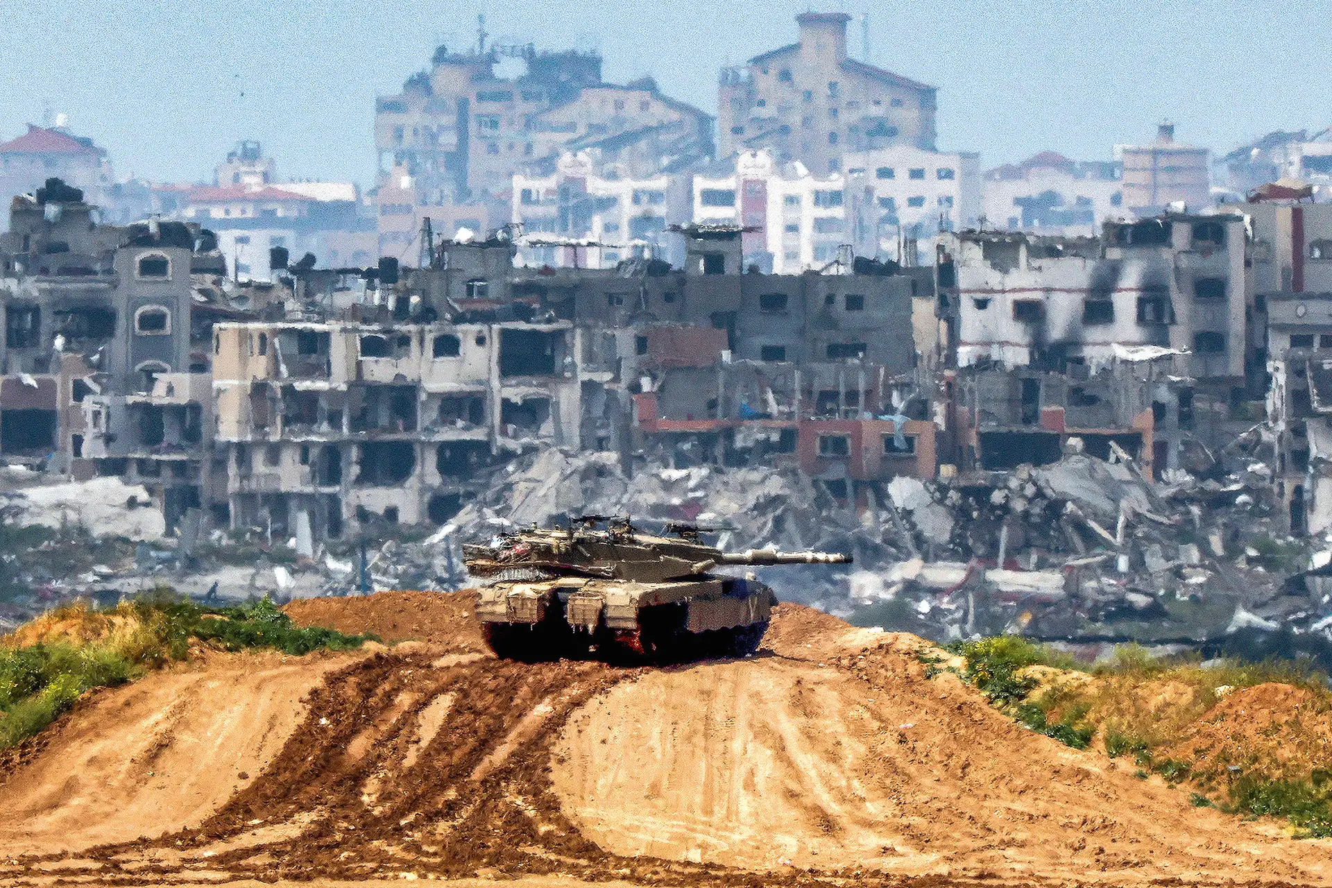 Tanque israelita num cenário de destruição junto da fronteira sul da Faixa de Gaza 