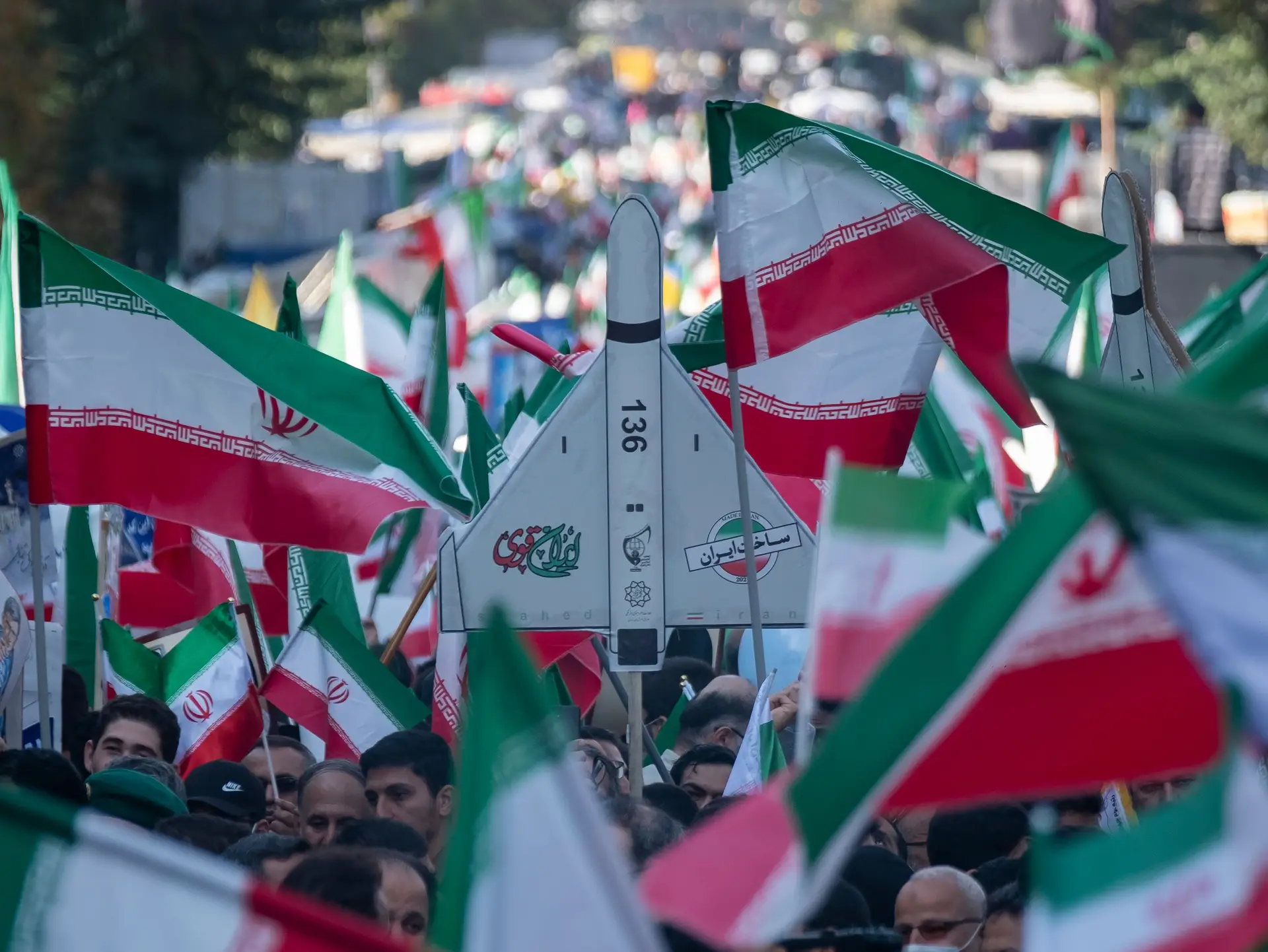 Um manifestante segura uma réplica do Shahed-136, um símbolo do poder militar iraniano nos últimos anos