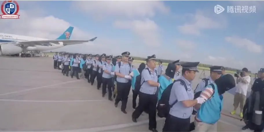 Captura de ecrã do vídeo distribuído no WeChat mostra a polícia chinesa a retirar os suspeitos do avião