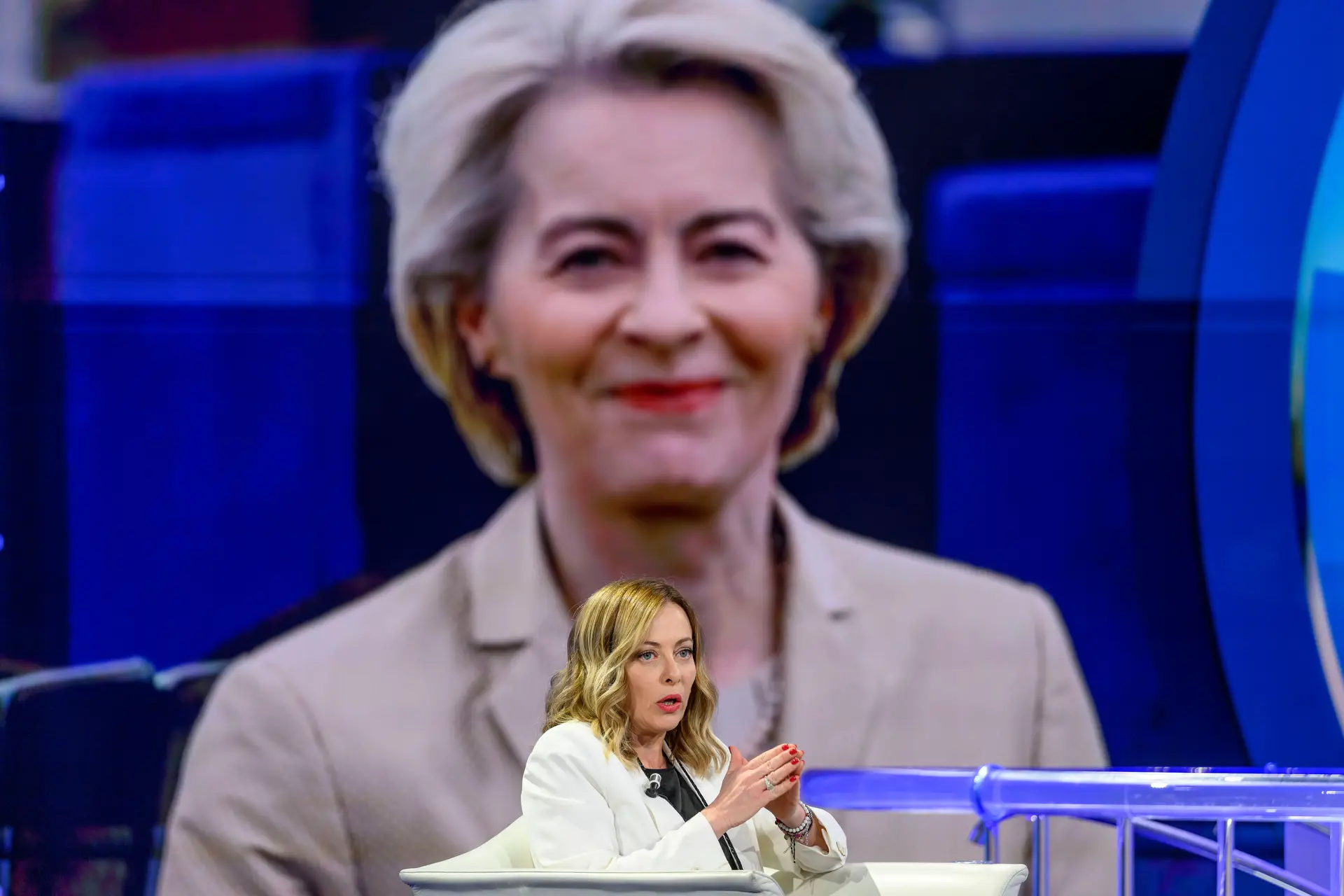 Giorgia Meloni, com fotografia de Ursula von der Leyen em fundo
