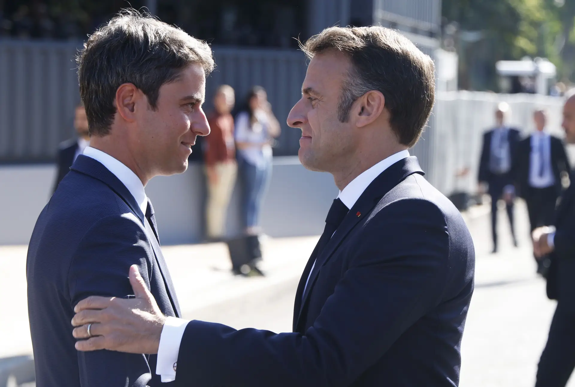 O primeiro-ministro demissionário, Gabriel Attal, cumprimenta Emmanuel Macron nas celebrações do Dia da Bastilha, a 14 de julho