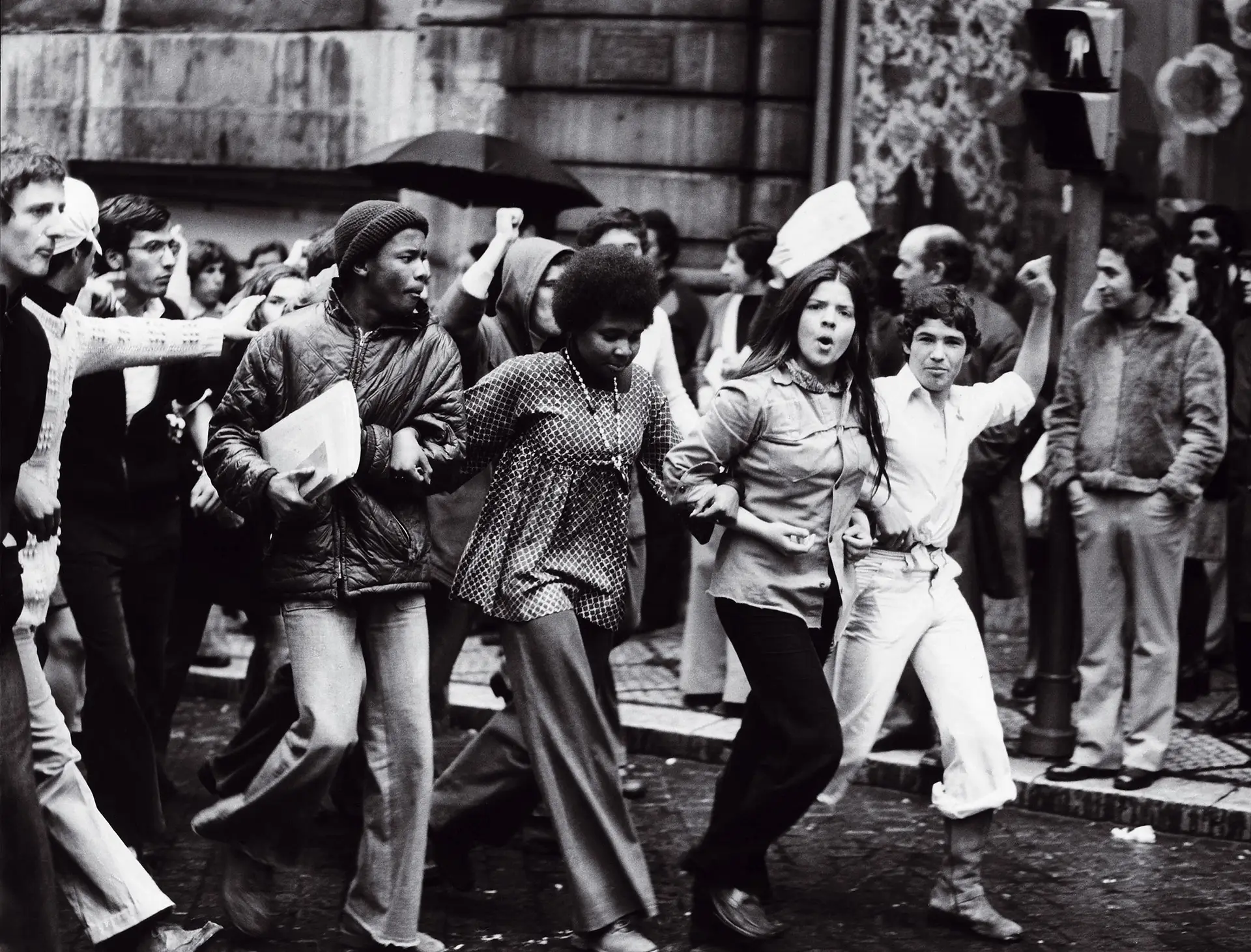 O 25 de Abril representou a explosão do prêt-à-porter e o fim de modistas, costureiras e até alfaiates, até aí donos da moda em Portugal. Esta imagem, captada em Lisboa no dia da Revolução, foi recentemente utilizada num outdoor do Bloco de Esquerda