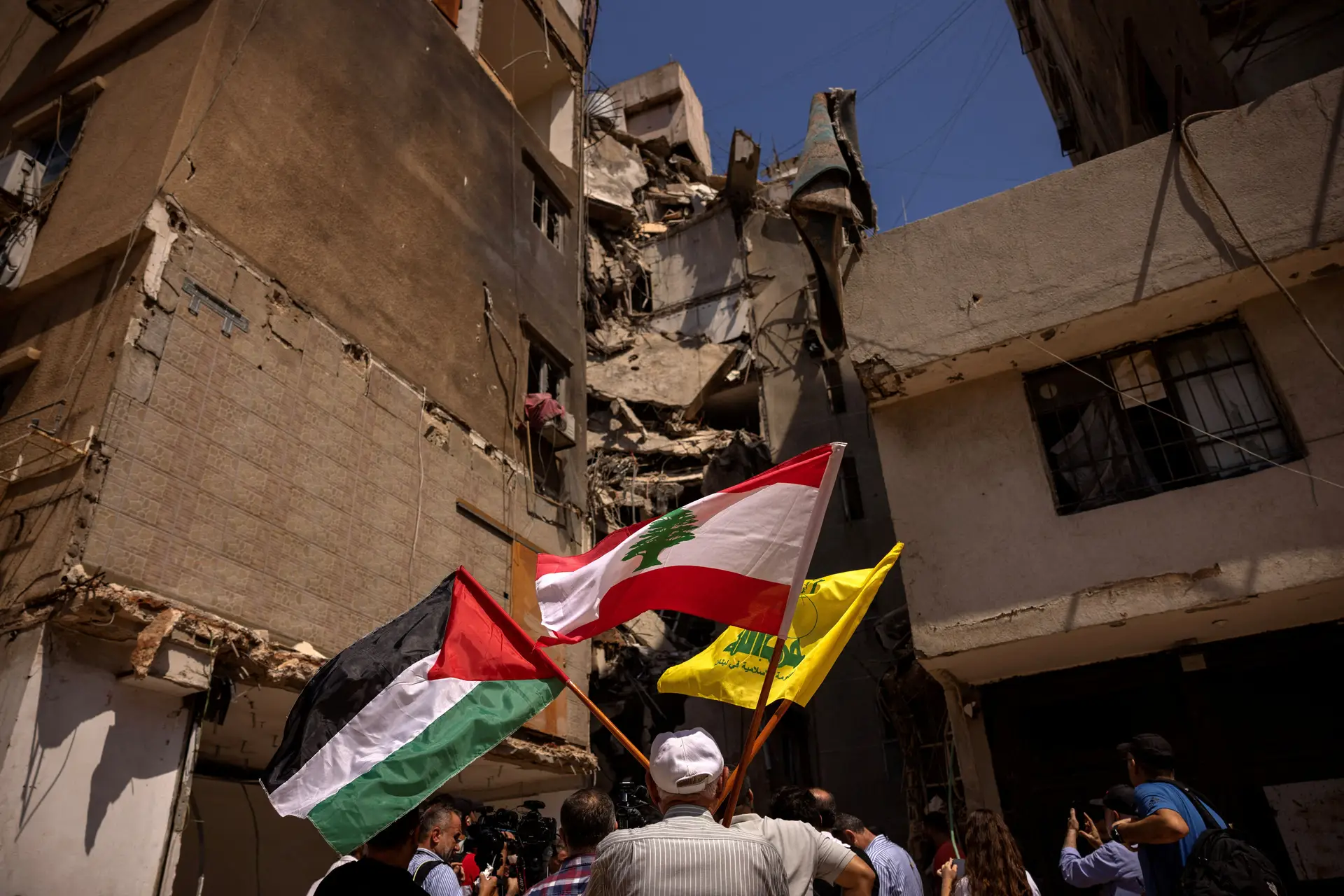 Um homem segura a bandeira da Palestina, Líbano e Hezbollah