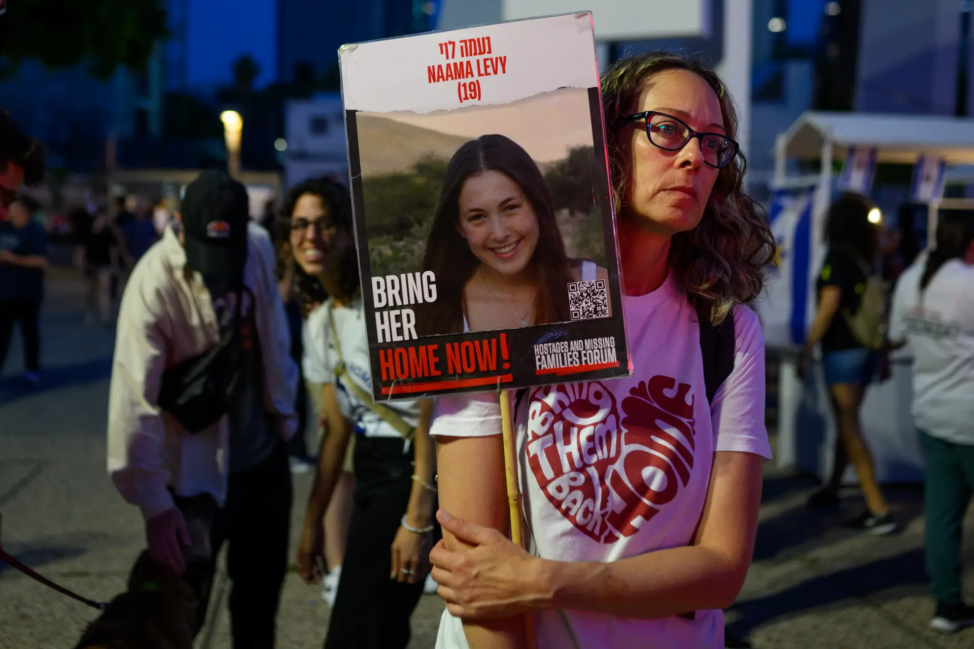 Uma mulher com um cartaz com a fotografia de Naama Levy, uma das cinco mulheres do exército israelita raptadas pelo Hamas a 7 de outubro