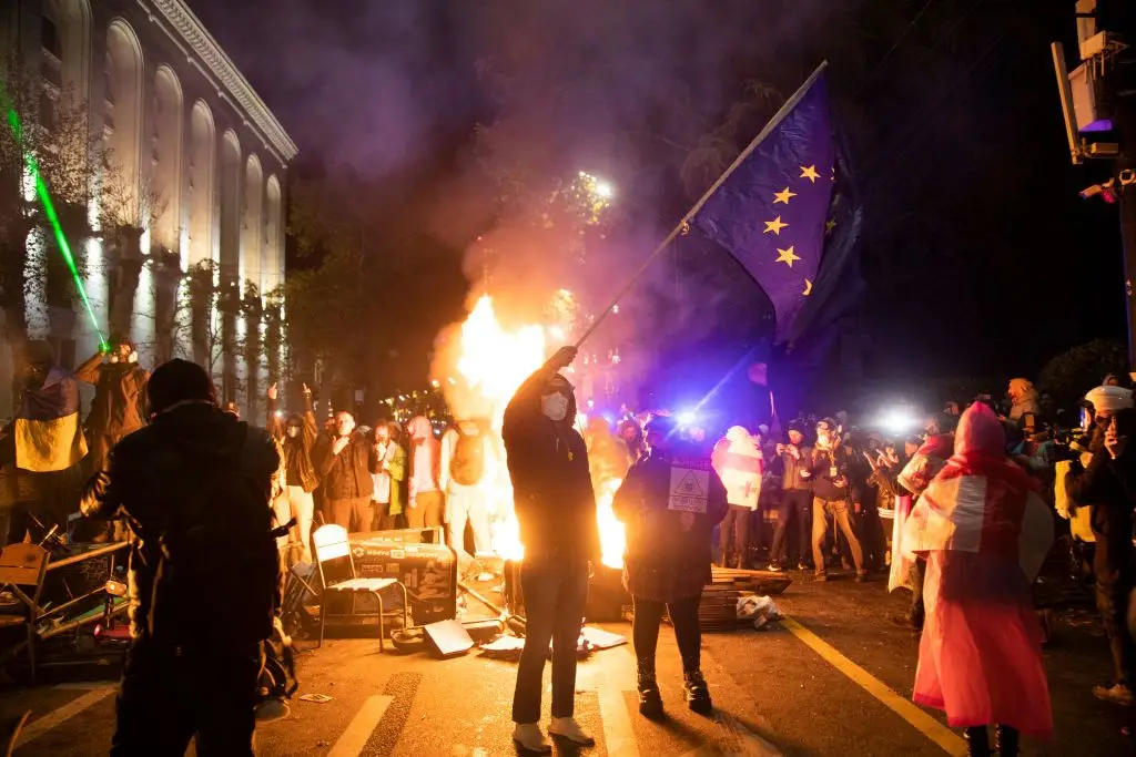 Manifestantes reúnem-se em frente ao parlamento georgiano, em Tbilisi, em protesto contra a decisão do Governo, pró-russo, de suspender as negociações de adesão à UE