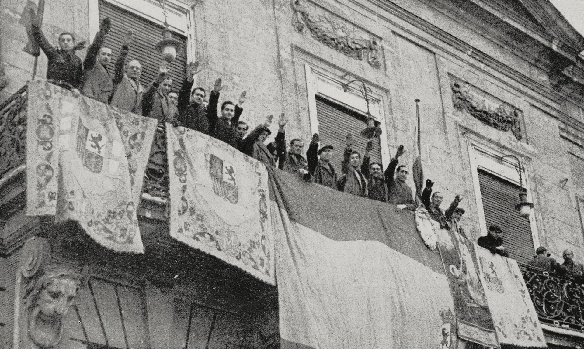 Um grupo de altas patentes saúda, a partir do balcão da Real Casa dos Correios, na praça da Porta do Sol, em Madrid, as tropas franquistas que entram na cidade, em abril de 1939