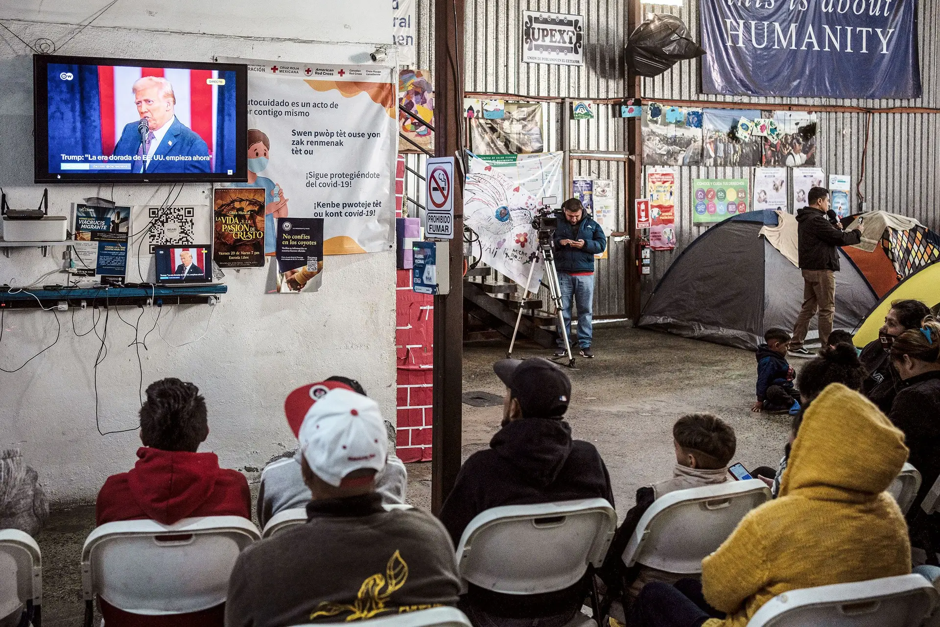 Migrantes latino-americanos assistem à tomada de posse do Presidente dos EUA, em Tijuana