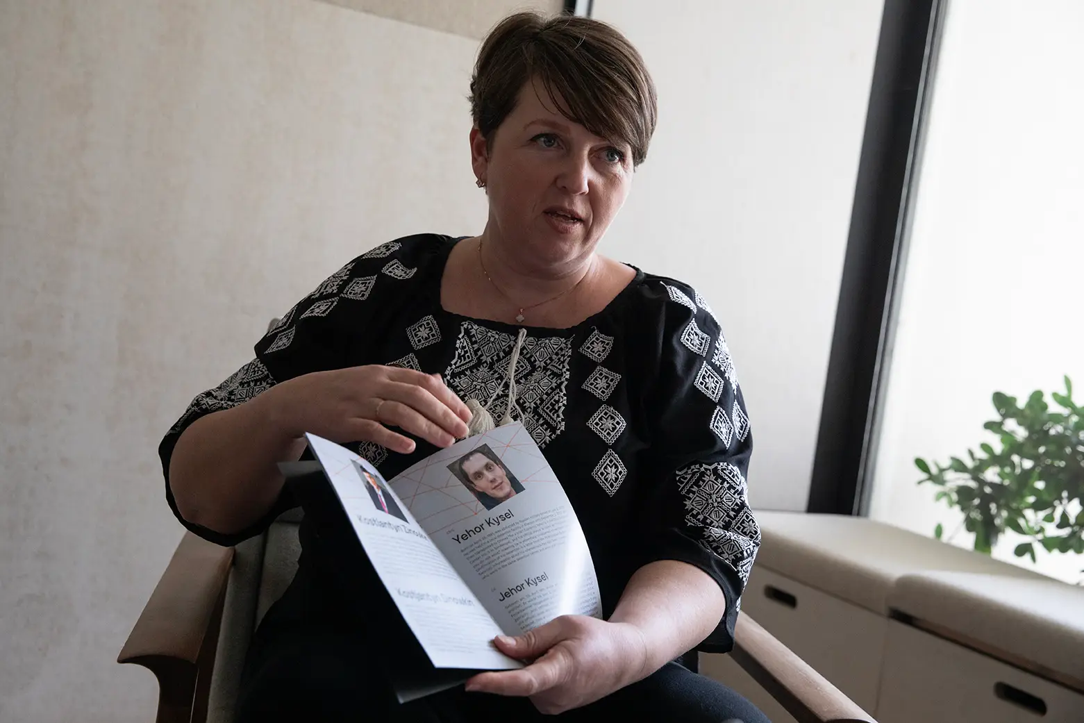 Olena Yahupova, aqui fotografada com o livro que traz sempre para dar às pessoas que encontra, com algumas histórias de outras pessoas presas como ela