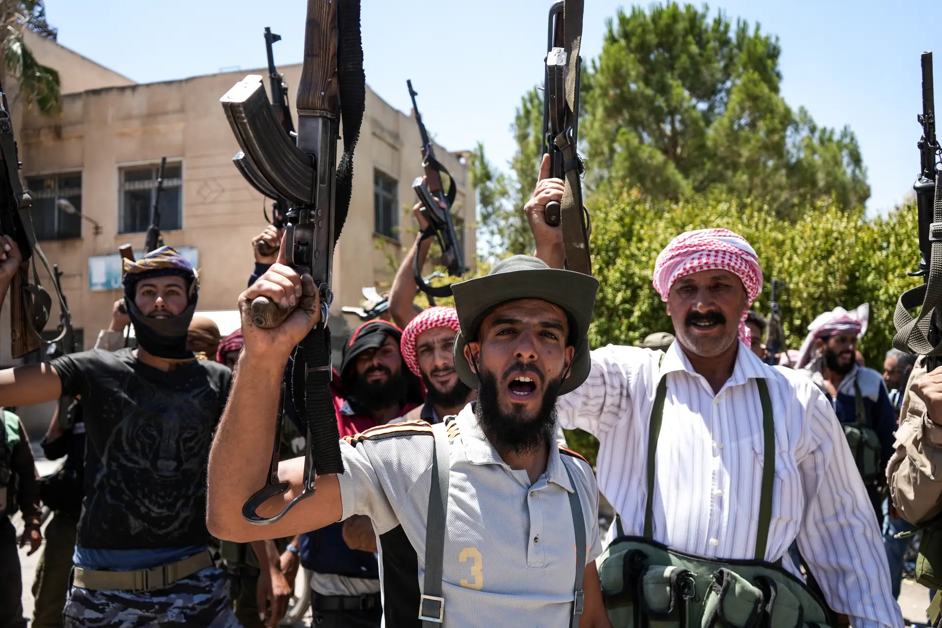 Membros de tribos beduínas, de armas em riste, mobilizados para combater os drusos, na região síria de Suwayda