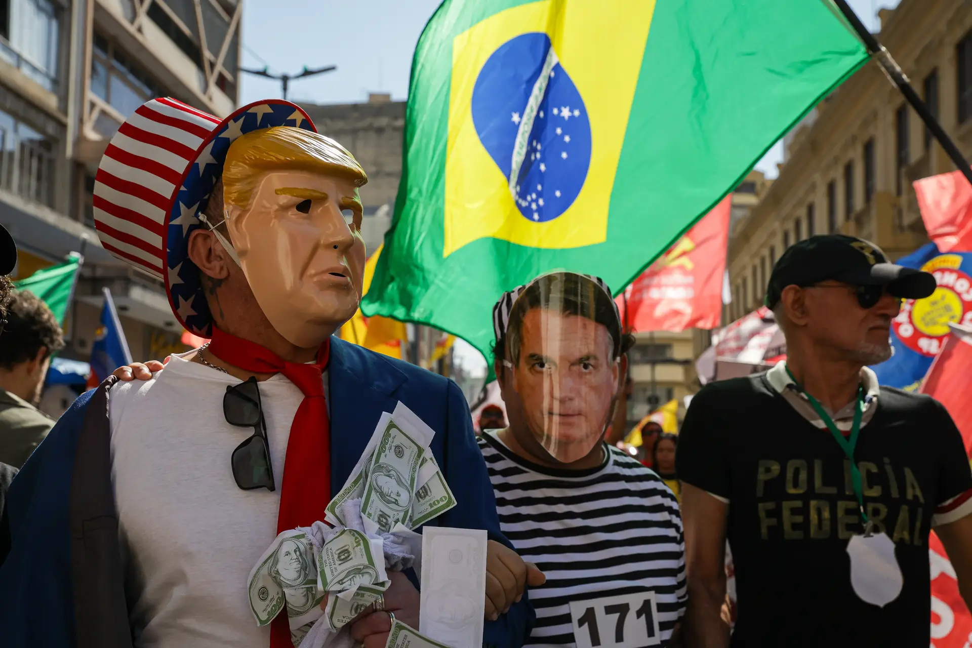 Manifestantes com máscaras de Donald Trump e Jair Bolsonaro protestam, em São Paulo, contra as tentativas do Presidente dos Estados Unidos para influenciar a vida política e judicial brasileira
