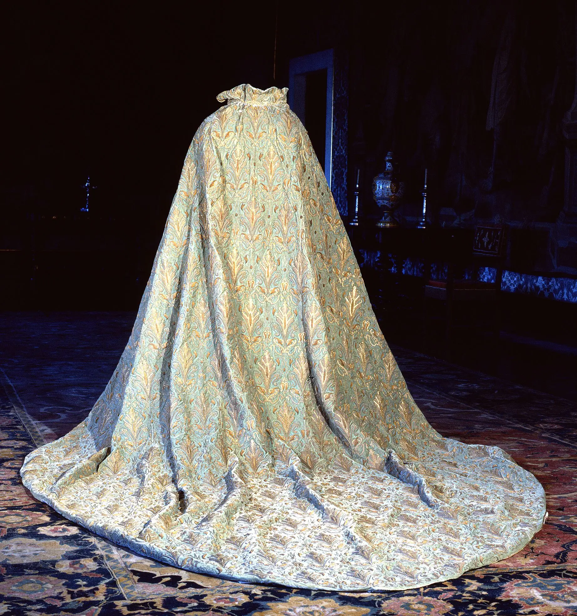 Um dos pontos altos da mostra é a exibição de um manto em veludo da rainha