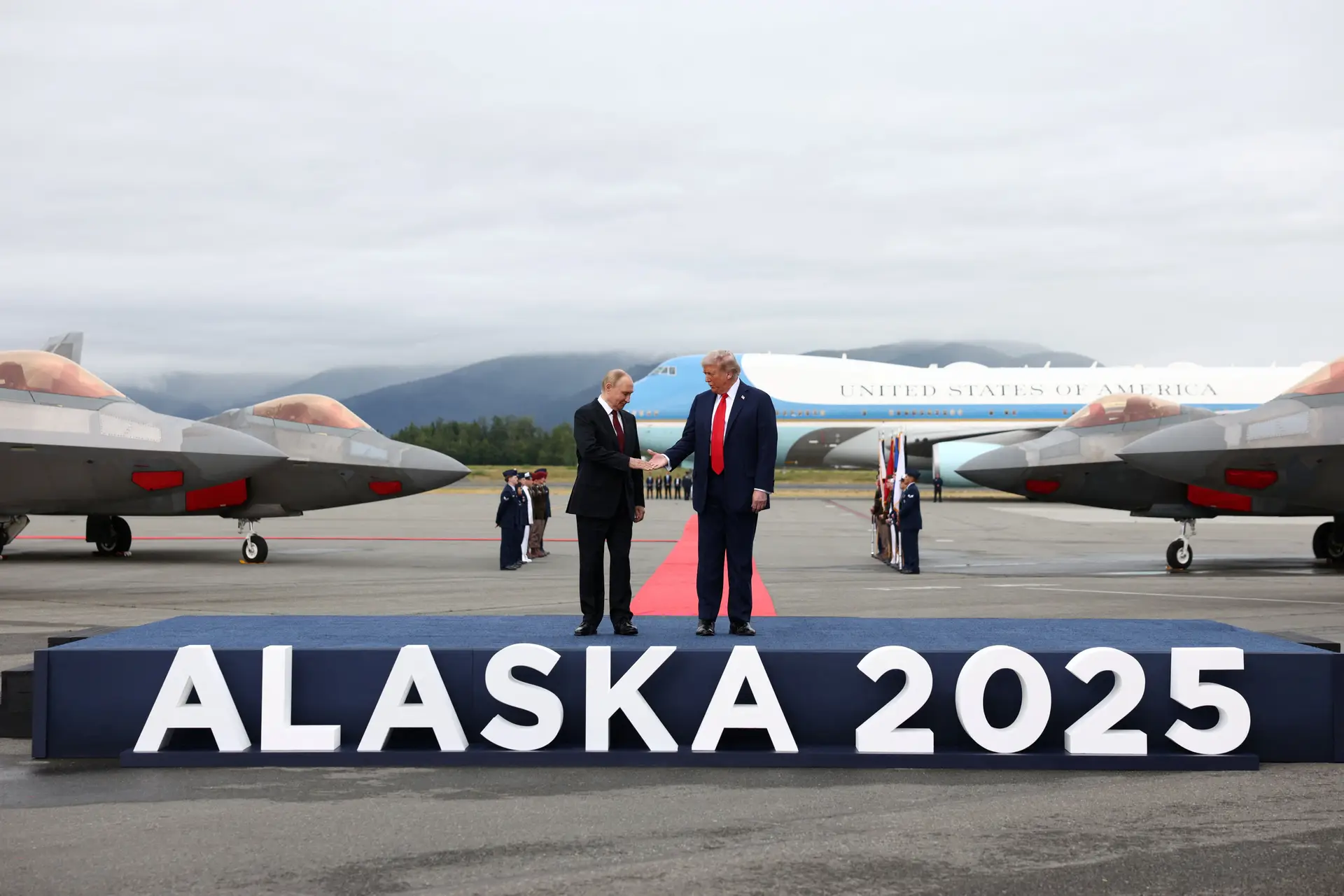 Vladimir Putin e Donald Trump cumprimentam-se num pódio na pista da Base Elmendorf-Richardson, em Anchorage, no Alasca