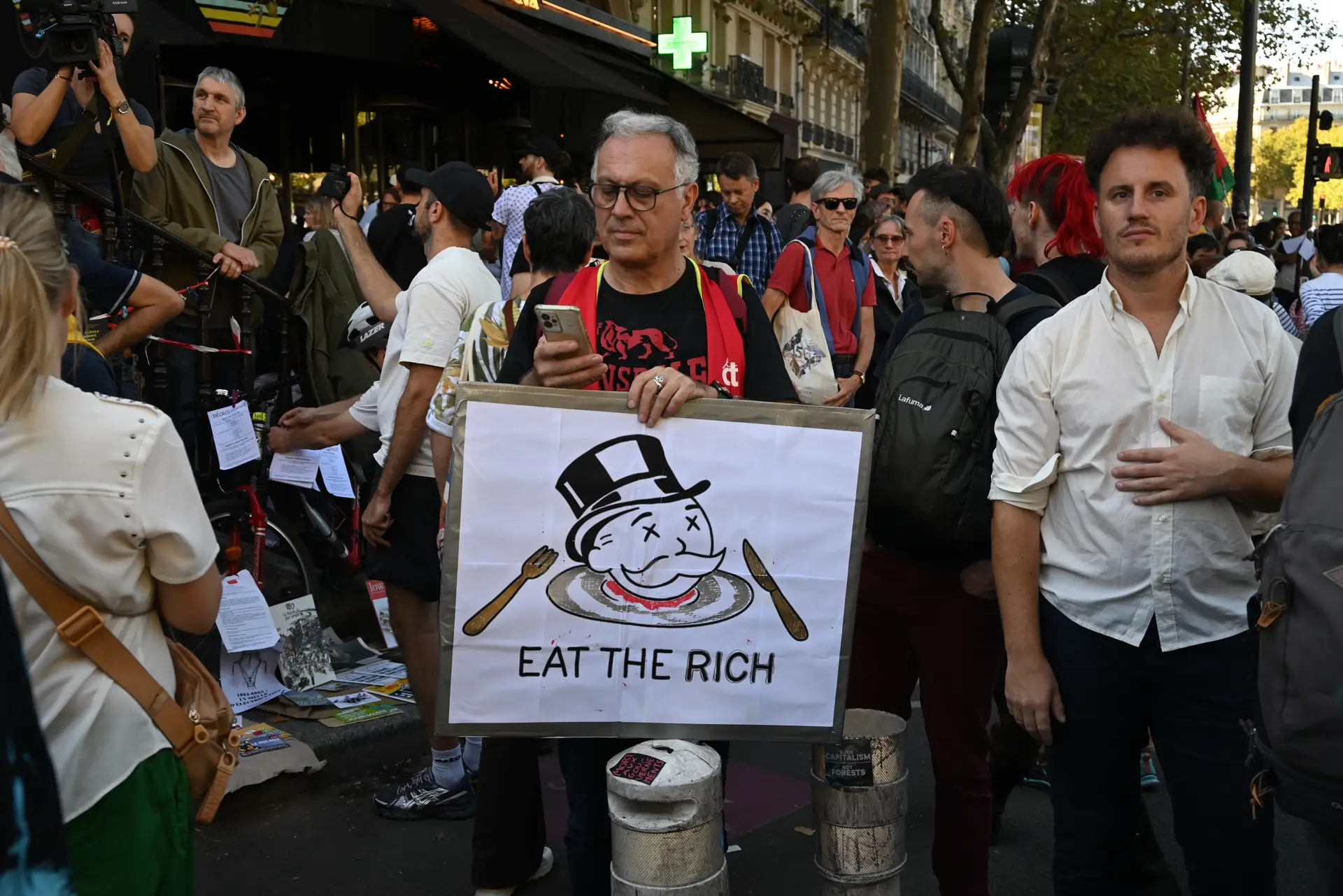 Manifestante na Praça da República. No cartaz lê-se “comer os ricos”
