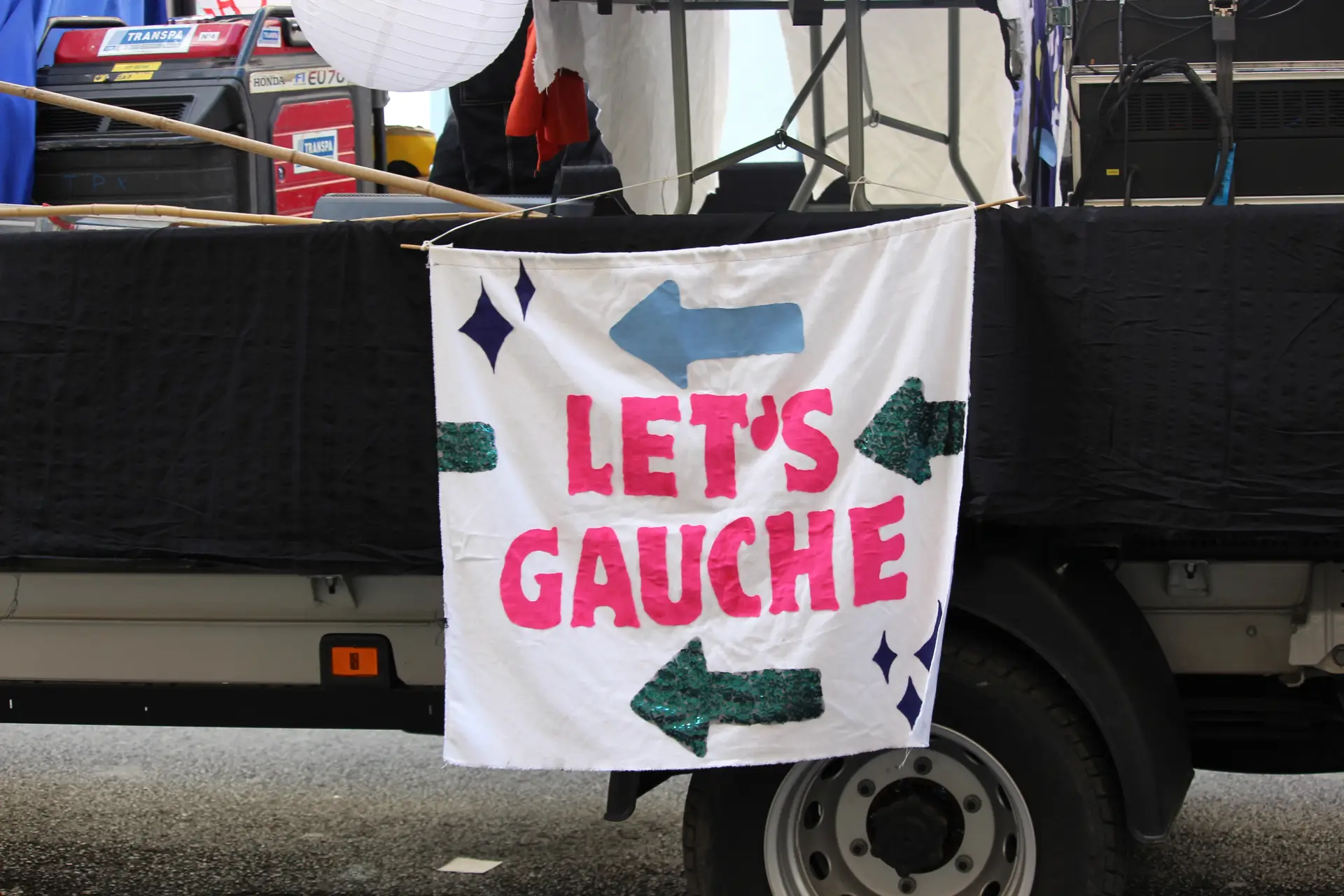 Cartaz de apelo à união das esquerdas no veículo que encabeçava o cortejo da Marcha das Resistências, saindo da Gare du Nord, em Paris, a 28 de setembro de 2025