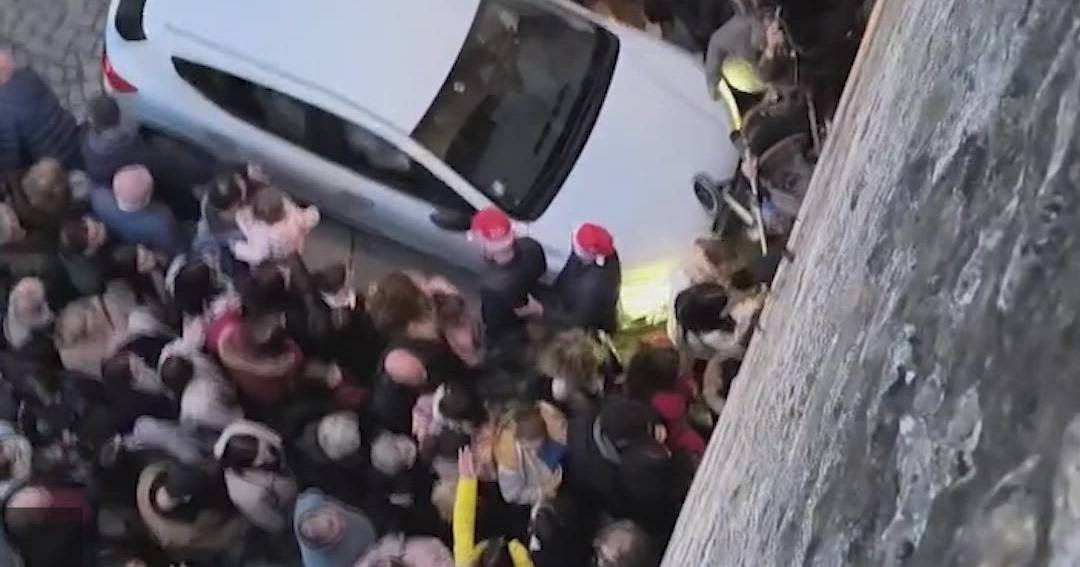 Carro circula entre a multidão na vila de Natal, em Óbidos