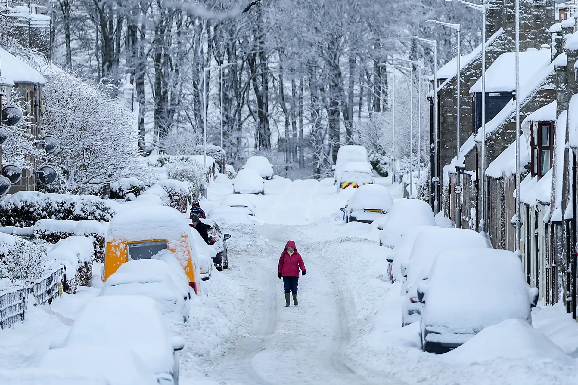 Uma pessoa tenta passar numa estrada coberta de neve em Huntly, Aberdeenshire, na Escócia.