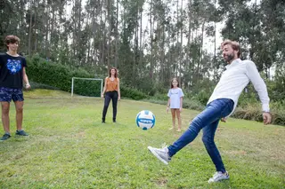 Ricardo a jogar à bola com a mulher e os filhos mais velho e a mais nova, no jardim da sua casa.