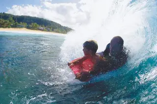 Mike Stewart a surfar com o filho, que hoje tem 1,88m e lhe consegue pegar ao colo.