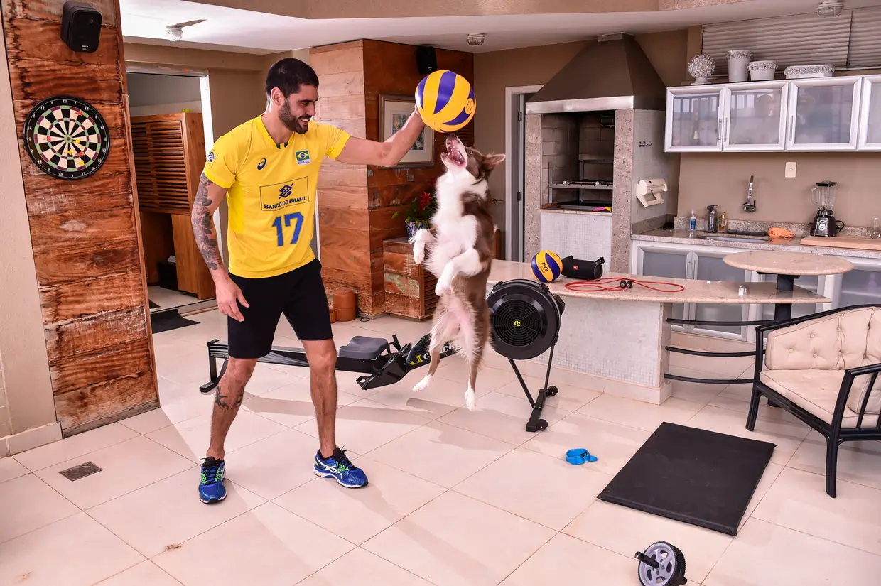 Evandro Guerra, jogador de voleibol brasileiro, a treinar com o cão