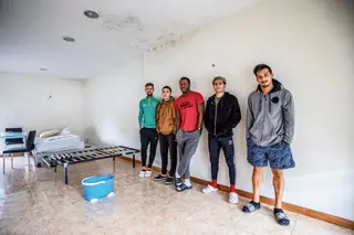 Nesta sala longe de casa há um colchão, duas cadeiras, uma mesa - e a água é aquecida ao sol dentro de garrafões na varanda