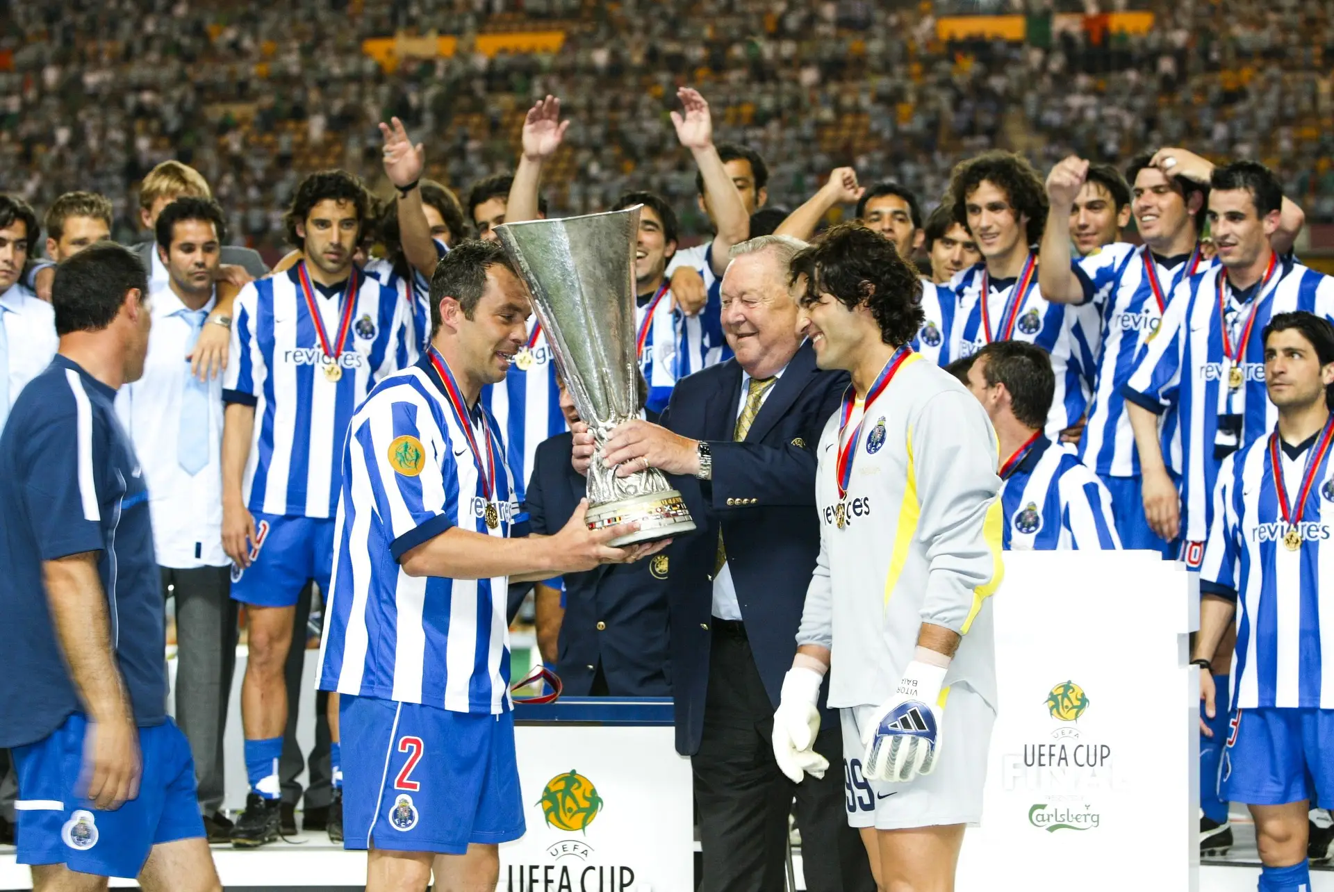 Jorge Costa recebe das mãos de Lennart Johansson, sob o olhar de Vítor Baía, a Taça UEFA conquistada em 2003