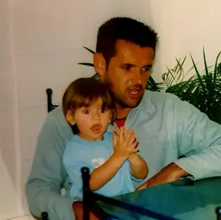 Guilherme ainda criança, ao colo do pai