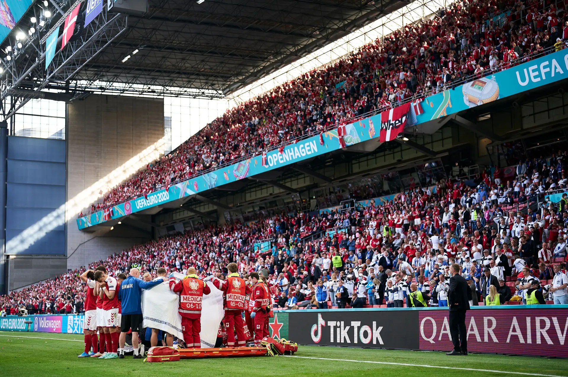 Os jogadores da Dinamarca e paramédicos a circundarem Christian Eriksen, durante as manobras de reanimação feitas no estádio Parken, em Copenhaga, após o jogador cair inanimado durante o Dinamarca-Finlândia