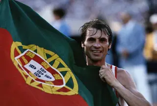Carlos Lopes, em 1984, agarrado à bandeira de Portugal, após ser o mais rápido a correr a maratona e a dar a primeira medalha de ouro ao país em Jogos Olímpicos