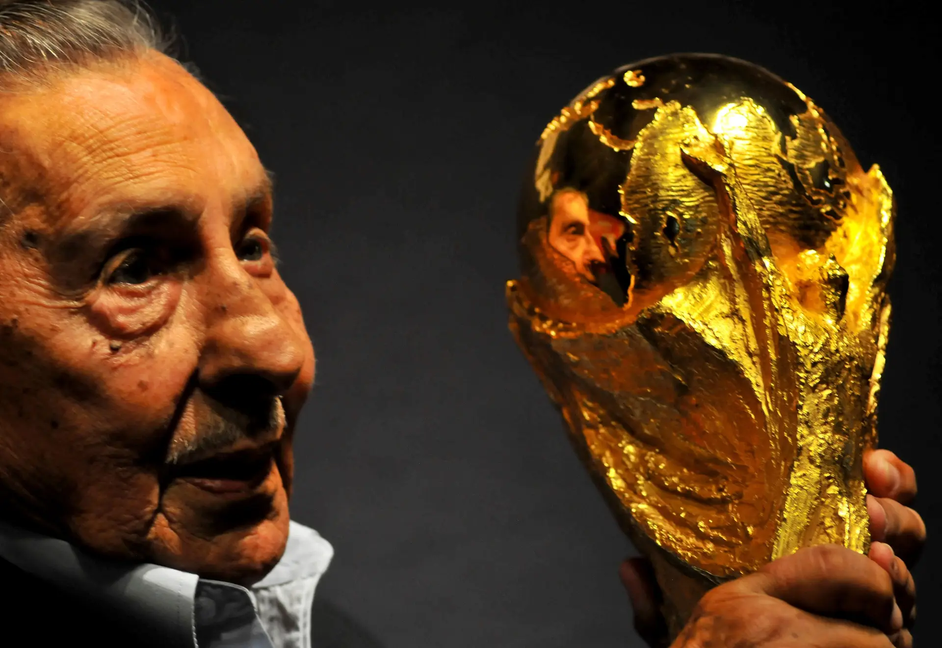 Alcides Ghiggia olha para o troféu de campeão do mundo, em 2013