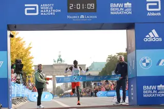 Eliud Kipchoge cruza a meta na maratona de Berlim, com a marca do novo recorde do mundo fixado