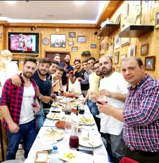 No jantar de despedida de solteiro. Hugo está ao fundo à direita