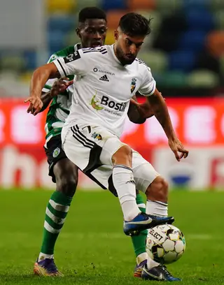 Hugo, do Farense, a disputar a bola com Nuno Mendes, do Sporting