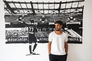 Em sua casa, junto de um quadro que o representa na Académica