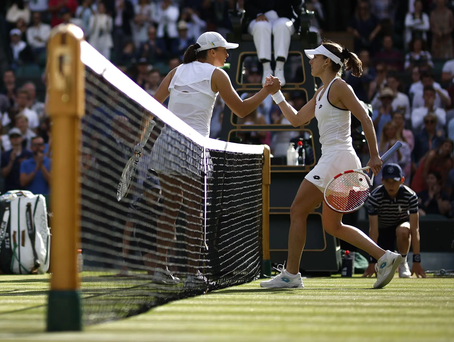 Alizé Cornet e Iga Swiatek a cumprimentarem-se no final do seu jogo, na edição de 2022 do Grand Slam inglês