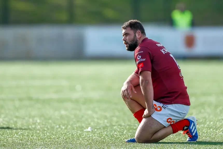 Jogador de rugby que corre com a bola