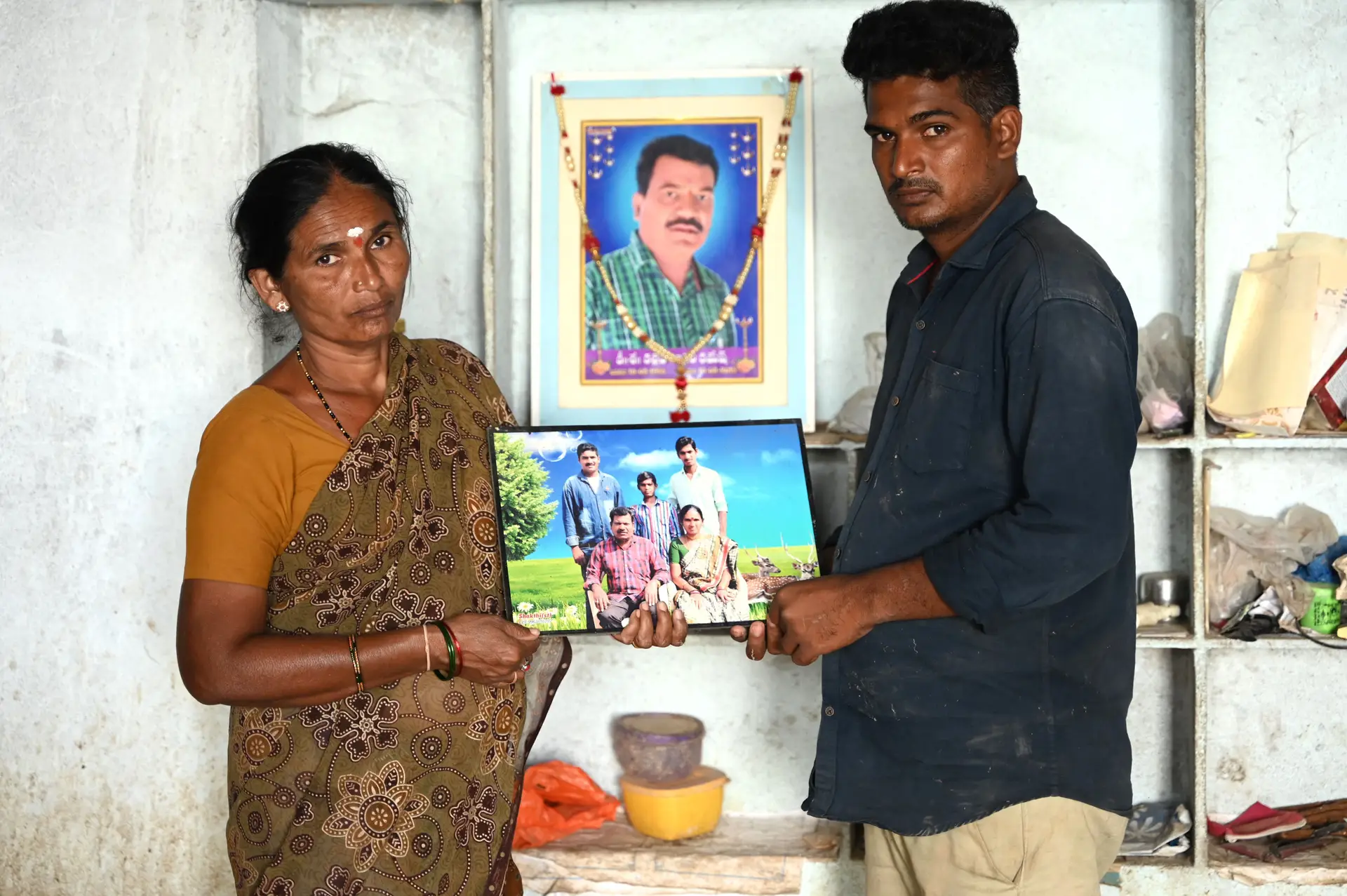 Kalleda Vinoda segura um retrato do marido Ramesh, que morreu nas construções do Mundial, juntamente com o filho Sravan, em Velmal, na Índia