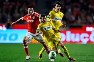 O lateral (no meio) tenta fugir a Gaitan do Benfica